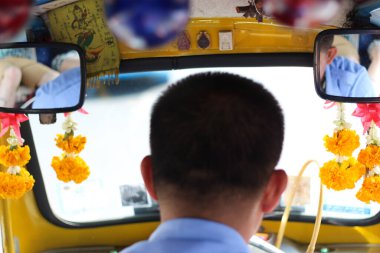 Tayland 'da Tuk Tuk' un içinden bir görüntü. Çiçek çelenkleri ve ışıklarla dekoratif dokunuşları görebilirsiniz..