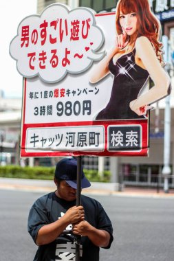 Japonya 'da yetişkin eğlence yeri tabelası tutan bir adam.