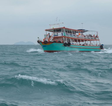 Pattaya yakınlarındaki deniz dalgalarında turistlerle dolu bir tekne.