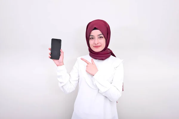 Muslimka Usmívá Ukazuje Smartphone Unesena Muslimská Dívka Stojící Bílém Pozadí — Stock fotografie