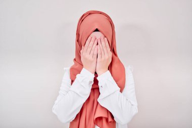 Başörtüsü Müslüman kız depresyonda ve üzgün, ağlıyor, ya kapalı ya da elleriyle yüzünü kapatıyor.