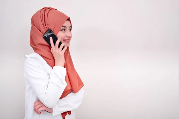Muslim woman calling, hijab girl standing and calling with mobile phone, she aligned left for blank text area