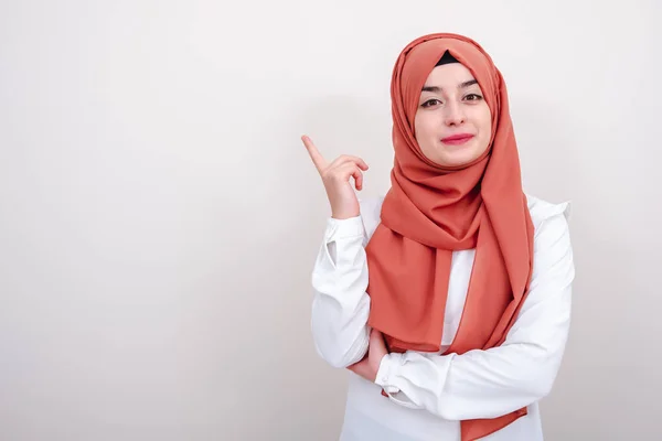 Gülen hijab müslüman kadın boş kopya alan alana parmak işaret, kız parmaklarını işaret ve kamera arıyor