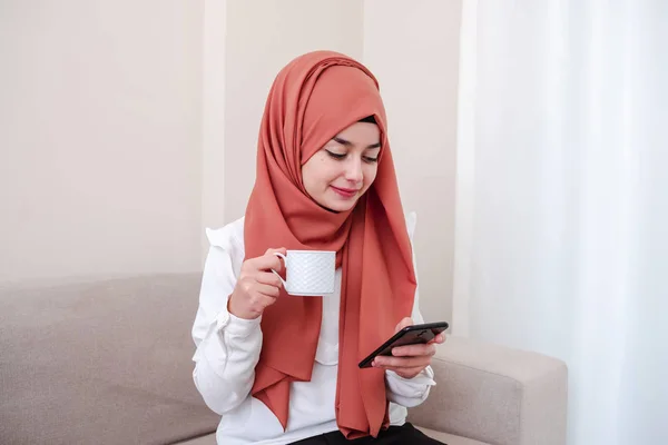 Hijab Mädchen Nutzt Smartphone Für Soziale Medien Und Trinkt Kaffee — Stockfoto