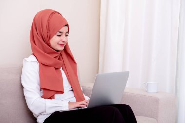 Bilgisayar veya dizüstü bilgisayar kullanan ve posta iletisi yazan Müslüman kadın