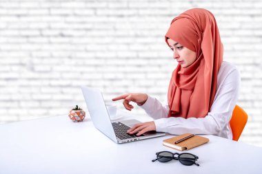 Müslüman kadın ofiste bilgisayar ile çalışmak, hijab müslüman kız dizüstü ekran işaret