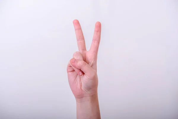 A woman hand showing victory sign or gesture on isolated background