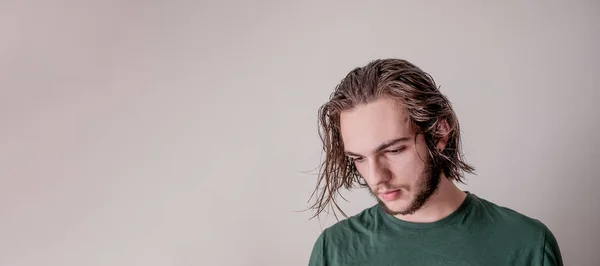 Young guy looking down, young boy or man, portrait photo of wet hair model with isolated blank area