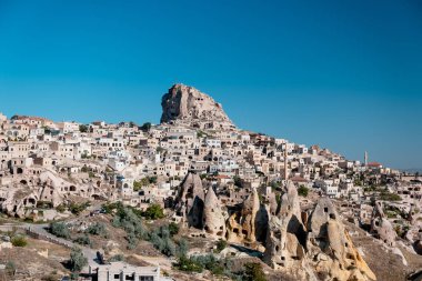 Uchisar, Kapadokya / Türkiye - Haziran 2019: Uchisar Kasabasının panoramik şehir manzarası fotoğrafı, gökyüzü açık mavi.