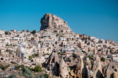 Uchisar, Kapadokya / Türkiye - Haziran 2019: Uchisar Kasabasının panoramik şehir manzarası fotoğrafı, gökyüzü açık mavi.