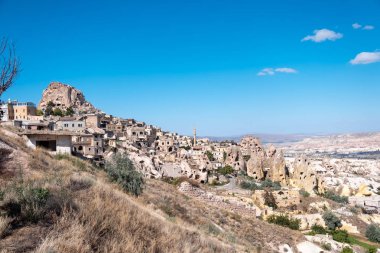 Uchisar, Kapadokya / Türkiye - Haziran 2019: Uchisar 'ın Pigeon Valley ile oyulmuş eski antik evlerin panoramik fotoğrafı