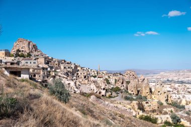 Uchisar, Kapadokya / Türkiye - Haziran 2019: Uchisar 'ın Pigeon Valley ile oyulmuş eski antik evlerin panoramik fotoğrafı