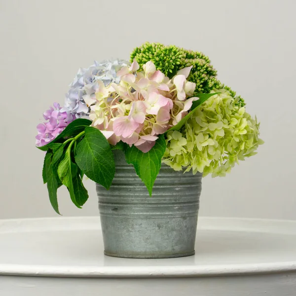 Delicate bouquet of green and pink hydrangea in a metal bucket
