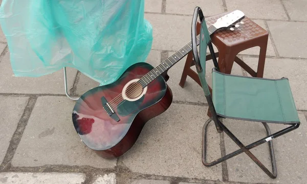 Guitarra Lado Uma Cadeira Dobrável Rua — Fotografia de Stock