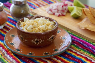 Meksika mutfağı, tavuk pozole turp, limon ve tost, şili de rbol ve etigano renkli bir Meksika arka plan ile servis.