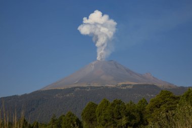 Popocatepetl volcano launches a spectacular fumarole next to Iztacchuatl mountain clipart