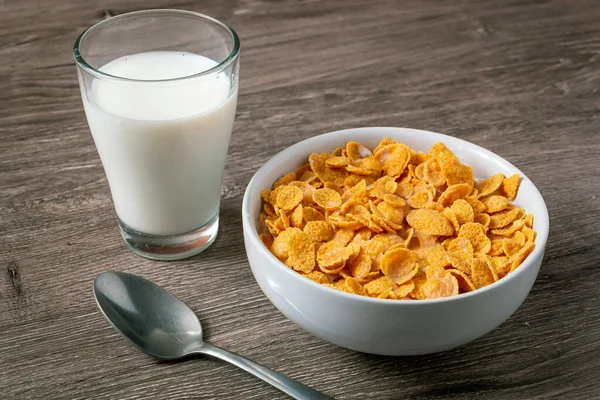 テーブルの上に健康的なコーンフレークとミルクとボウル — ストック写真