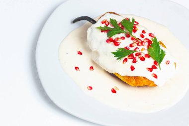 Meksika mutfağı. Beyaz arka planda Şili en nogada, minimum konsept. Meksika yemeği