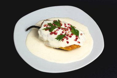 Meksika mutfağı. Siyah arka planda Şili en nogada, minimum konsept. Meksika yemeği