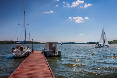 Masuria, the land of 1000 lakes. Yachts are moored at the marina clipart