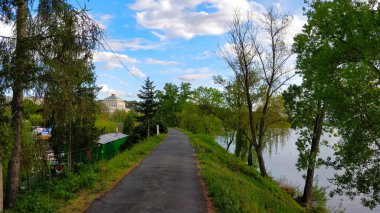 Prag 'da güzel bir bahar günü ağaçlarla kaplı nehir kenarındaki patika.