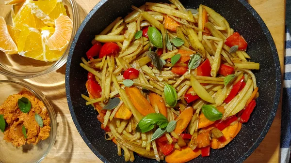 Detail of delicious vegan dish made of paprika, carrot, potatoes, and orange.
