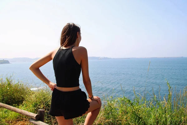 Girl watching the sea from a mountain.