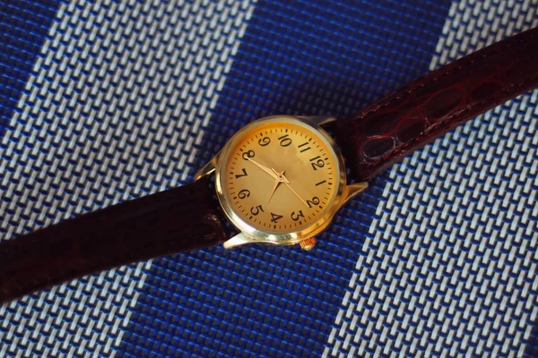 Quartz watch on a white and blue background.
