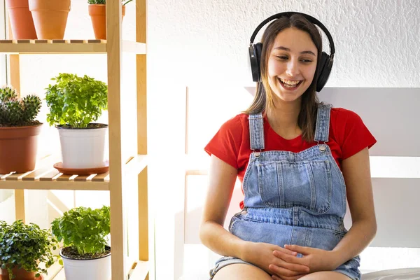 Young woman with headphones listening to music in bed. Concept of listening to music in bed.