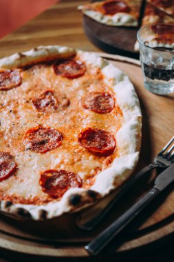 Güzel pizza biberli ahşap bir masaya yemek için hazır..