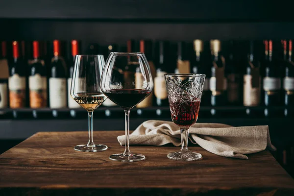 バーやワイン ショップに木製のテーブル ワインの異なった色の眼鏡 — ストック写真