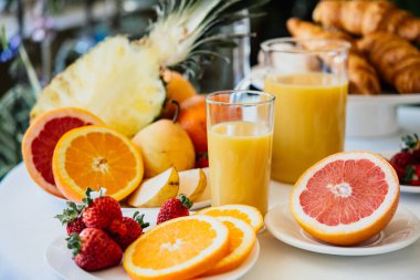 Taze meyve ve bir kahvaltı masasında portakal suyu