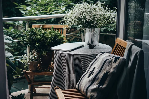 Güzel teras ya da balkon küçük masa, dizüstü bilgisayar ve çiçekler