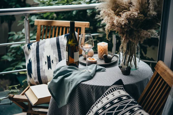 Güzel teras ya da balkon mumlar, şarap, gözlük ve kitap bir tablo ile