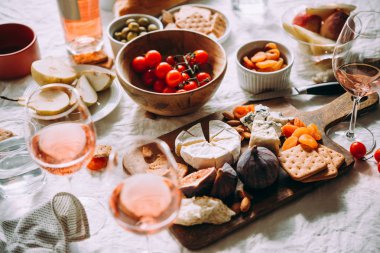 Bir yemek masası çeşitleri peynir, meyve ve gül şarap ile görev yaptı..