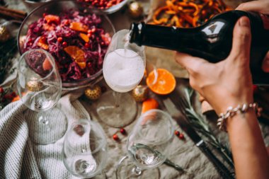 Arkadaşlarınızla bir akşam yemeği partide şampanya dökme. Yemek masası, Noel ve yeni yıl arifesinde kutluyor.