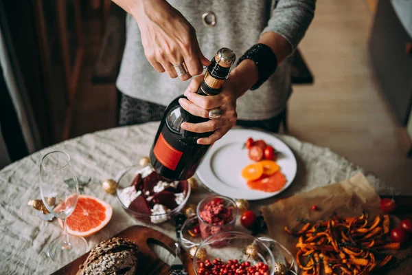 Frau Öffnet Flasche Champagner Tisch Essen Weihnachten Oder Silvester Feiern — Stockfoto