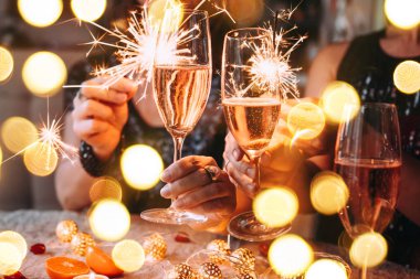 Noel 'i ya da yılbaşı partisini Bengal ışıkları ve gül şampanyasıyla kutlayan arkadaşlar.