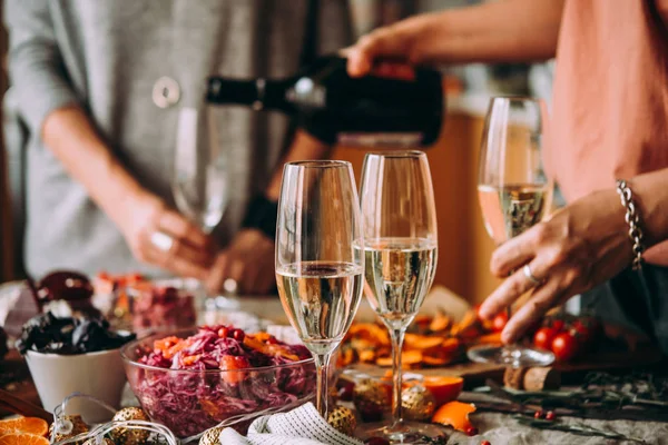 友達とのディナー パーティーでシャンパンを注ぐ クリスマスや新年の前夜を祝う夕食のテーブル — ストック写真