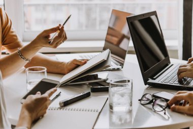 Dizüstü bilgisayarlar, cep telefonları ve dizüstü bilgisayarlar yaratıcı ofiste çalışan tabloda. Başarılı takım çalışması ve iş başlangıç kavramı.