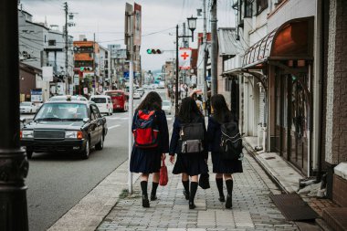 Japon okul öğrencilerin Kyoto, Japonya'nın caddeleri boyunca yürümek.