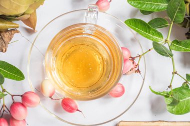 Bal açık bir bardak ve Tay meyve ve otlar vardır.