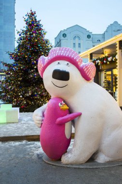 04-01-2017, Moskova, Rusya. Şehrin sokaklarında yeni yıl tatili için şenlikli süslemeler. Büyük bir kutup ayısı ve pembe bir penguen sarılma bir Noel heykeli