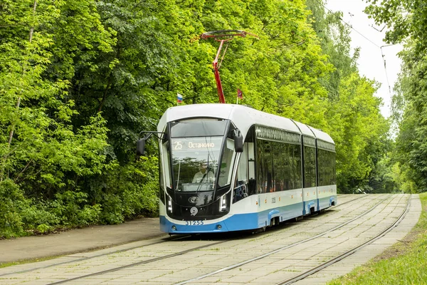 12-06-2019, Rosja, Moskwa. Niebieski biały tramwaj Moskiewski nowoczesny projekt transportu miejskiego. Tramwaj jedzie na szynach, lato jasne światła tła. — Zdjęcie stockowe
