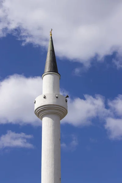 tall white minaret of a Muslim mosque an Islamic shrine, reading the Koran through a loudspeaker on the minaret