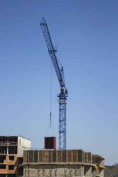 Movimiento de carga por una grúa de construcción. El suelo de materiales de la grúa. Construcción moderna tecnología monolítico marco de hormigón —  Fotos de Stock