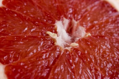 Kırmızı greyfurt eti, yakın çekim, arka plan. Sulu hamuru ile yarım greyfurt