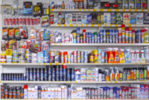 Blurred background shop window of auto cosmetics store and accessories for cars, many multi-colored bottles, background