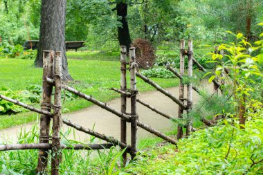 İnce çubuklardan yapılmış bir çit, kırsal bir yol boyunca ahşap bir çit. kırsal peyzaj, doğa duvar kağıdı arka plan