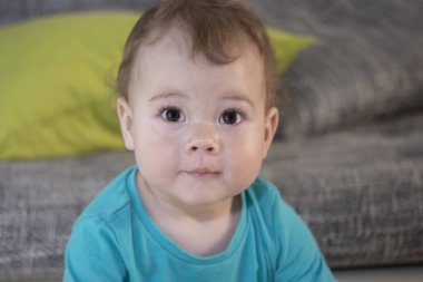 10 aylık sevimli bir sürpriz bebek kız erkek portresi. Bebek şaşırmış gözlerle bakar. Komik bir sürpriz küçük çocuk, yumuşak odak büyük bir portre